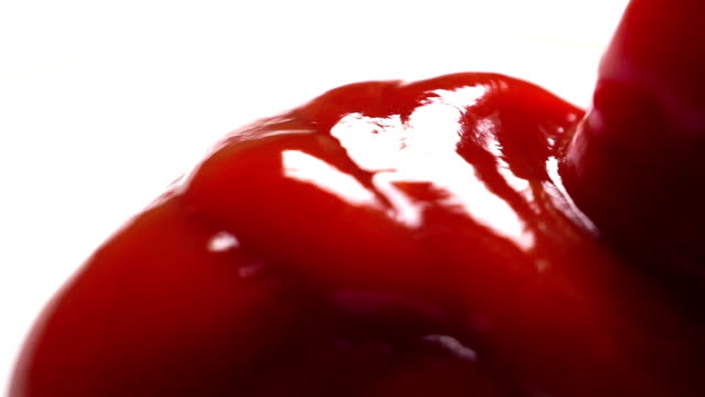 Putting tomato sauce on a white plate