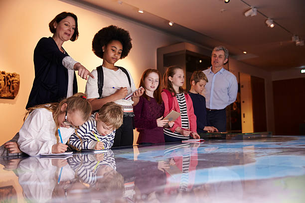istock Pupils On Trip To Museum Looking At Map And Making 542289566
