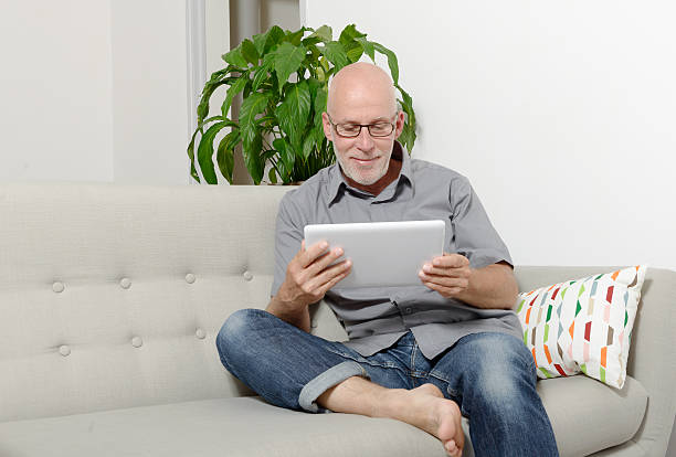istock Mature man at home websurfing on internet 542289570