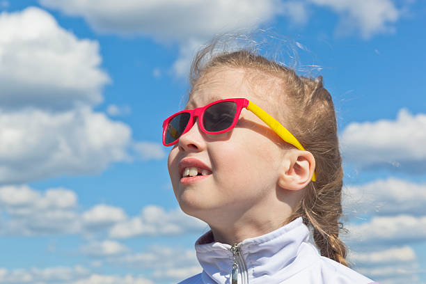istock Dreamy small girl against the sky with clouds 542292118