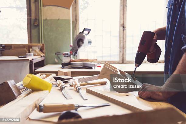 Man Using A Drill In A Carpentry Workshop Stock Photo - Download Image Now - Art And Craft, Blue-collar Worker, Business Finance and Industry