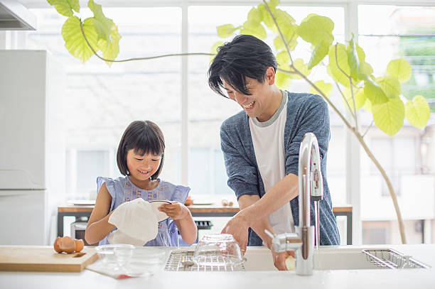 Father and daughter to the dishwashing Daughter to help wash the dishes. washing dishes photos stock pictures, royalty-free photos & images