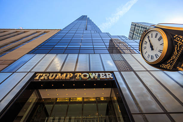 Looking up at the 5th avenue Trump Tower New York City, United States - March 12, 2016: Looking up at the 5th avenue Trump Tower with the gold name and clock in sight upper midtown manhattan stock pictures, royalty-free photos & images