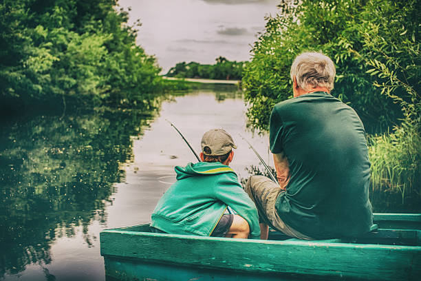 grand-père et garçon pêchant ensemble - fishing father son family photos et images de collection