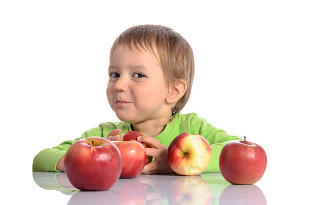 istock Cute child with red apples on white background 542297274