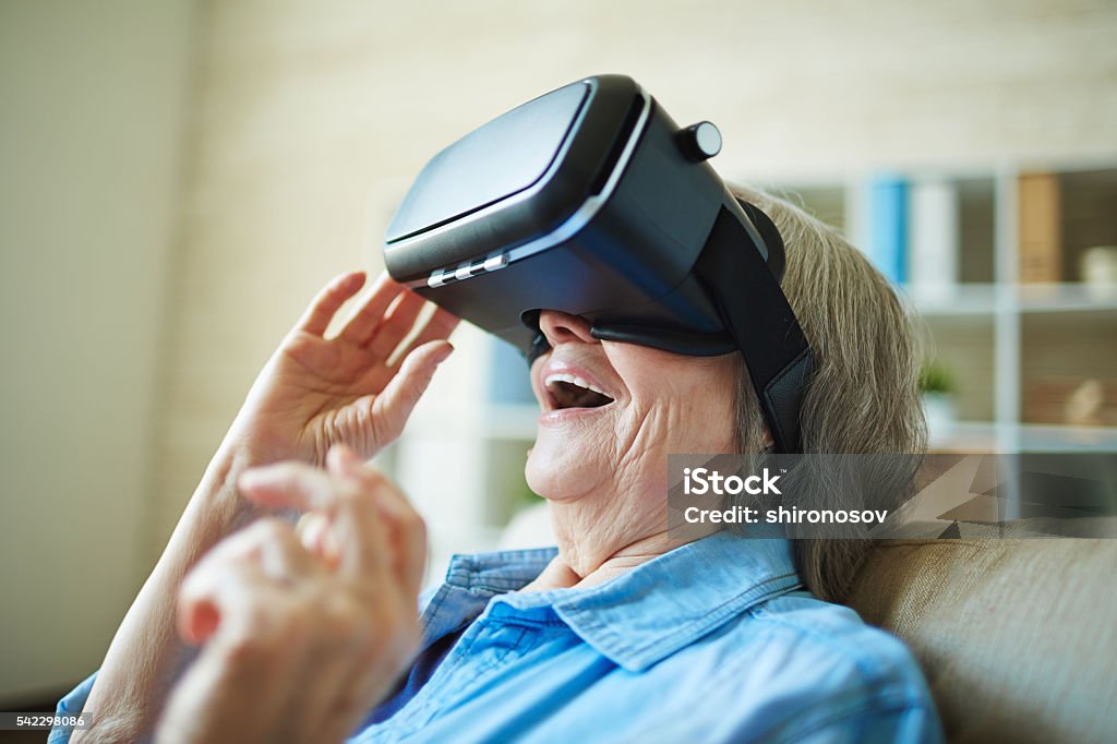 Modern granny Astonished senior woman with vr glasses Virtual Reality Simulator Stock Photo