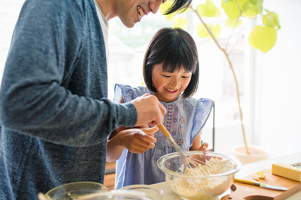 istock Father and daughter baking together 542299142