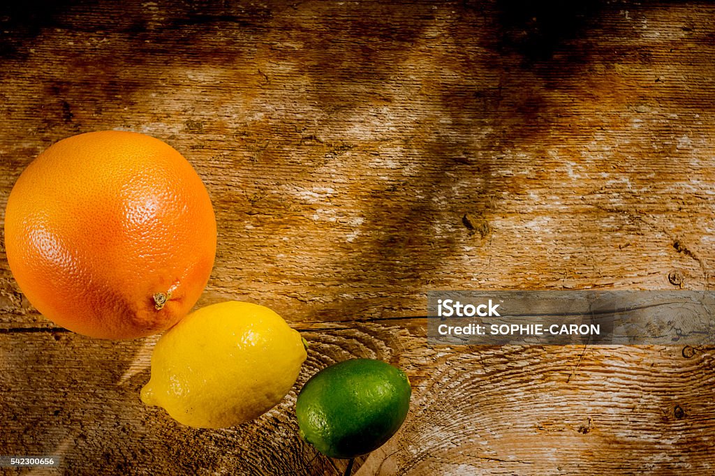 Three citrus fruits Three citrus fruits, pink grapefruit, lemon and lime on a wooden board. Citrus Fruit Stock Photo