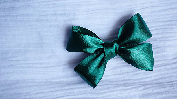 istock green ribbon bow on white fabric  background 542303346