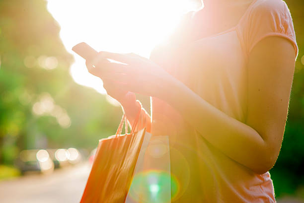 Women Resting After Shopping, Shopper woman hand shopping with a smart phone and carrying bags