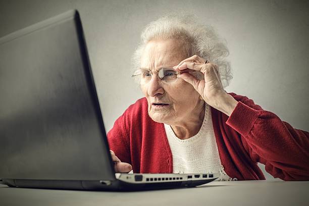 Old lady doesn't understand laptop stock photo