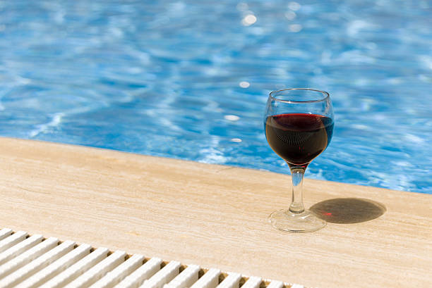 istock Full wine glass near the pools edge. 542305270