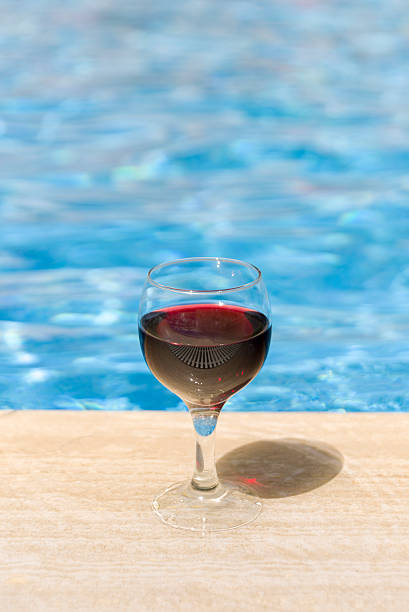 istock Full wine glass near the pools edge. 542305508