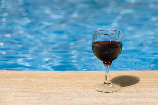 istock Full wine glass near the pools edge. 542305744