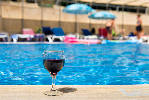 istock Full wine glass near the pools edge. 542305988