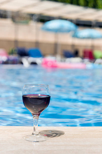 istock Full wine glass near the pools edge. 542306216