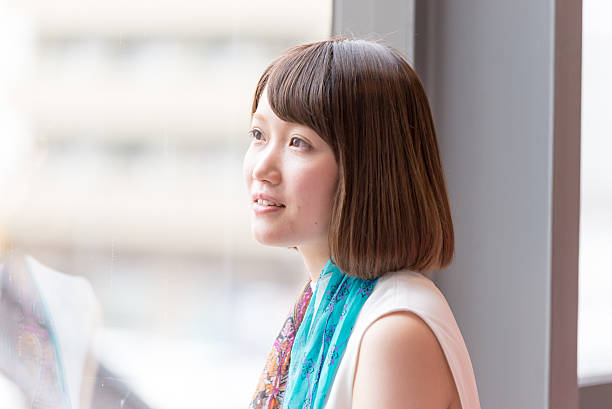 istock Japanese  young woman is looking outside through window 542306946