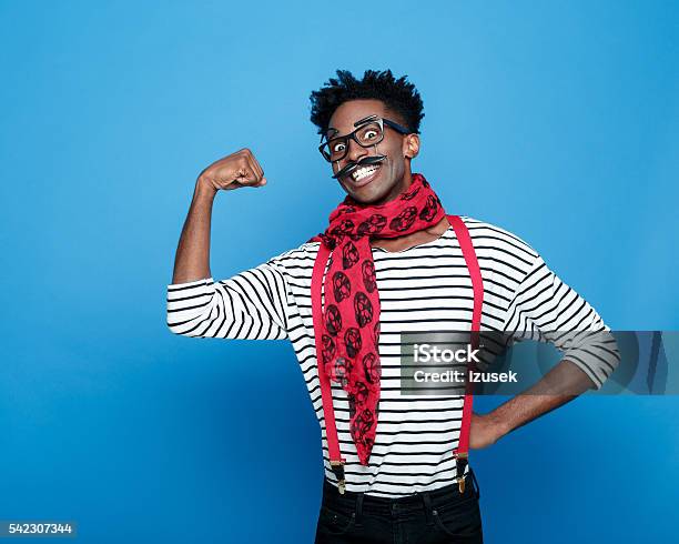Excited Afro American Guy In A French Outfit Flexing Bicep Stock Photo - Download Image Now