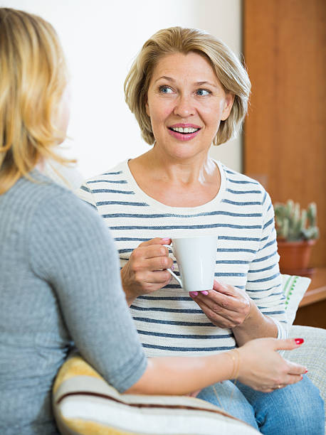 istock Two women drinking tea and talking at domestic interior 542307702