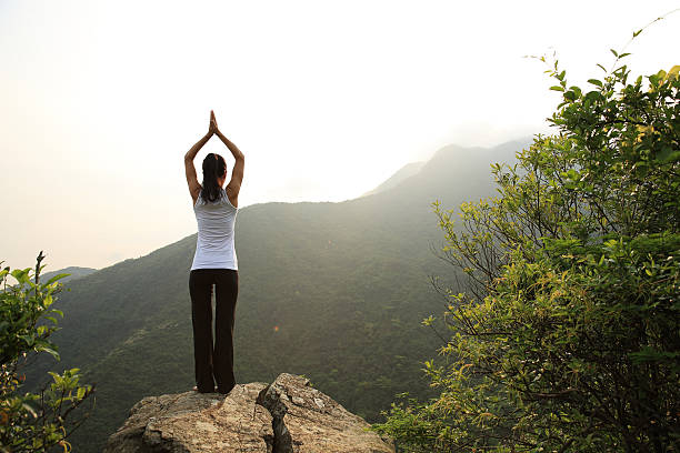 istock young woman practice yoga at mountain peak cliff 542308184