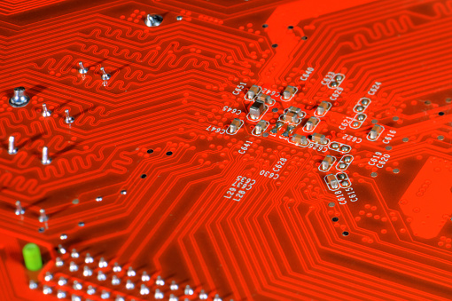 A orange circuit board, solderings and paths