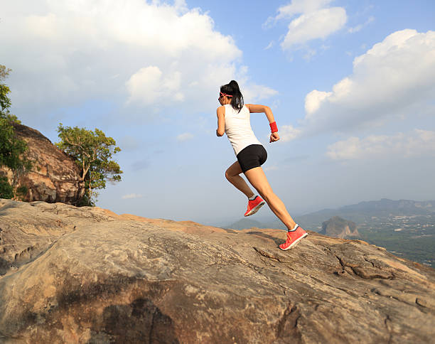 istock young asian woman runner running on mountain peak 542309190