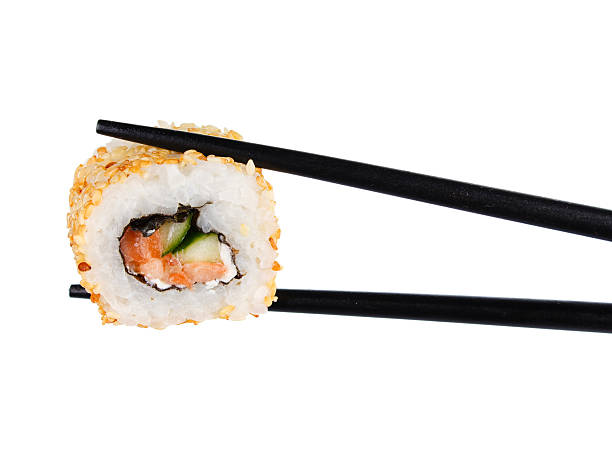 istock sushi roll in chopsticks Isolated on white 542309360