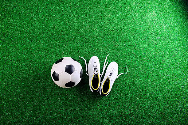 bola de futebol e tacos contra verde relva artificial, sho do estúdio - studio sho imagens e fotografias de stock