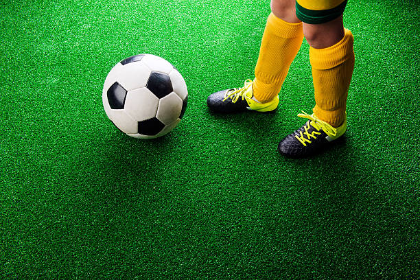 istock Unrecognizable little football player against green grass, studi 542310078
