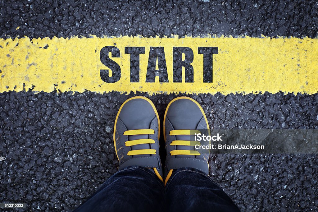 Start line Start line child in sneakers standing next to a yellow starting line Beginnings Stock Photo