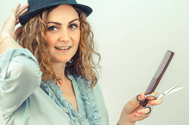 istock girl holding a pair of scissors and a comb 542310362