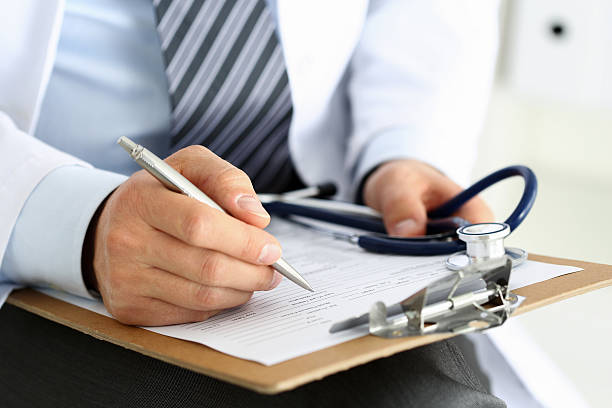 macho medicamento médico mano agarrando plata pluma de escribir - receta documento fotografías e imágenes de stock