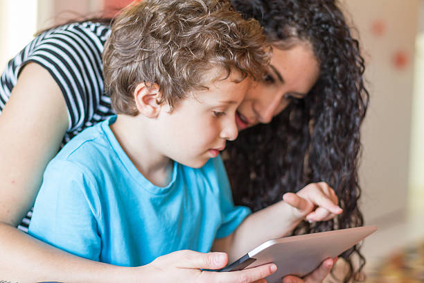 istock Young mother and her little boy using digital tablet 542311294