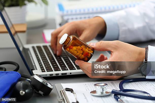 Médico De Medicina Macho Manos Mantenga El Recipiente De Píldoras Foto de stock y más banco de imágenes de Medicamento