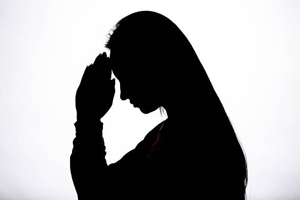 istock Woman praying silhouette 542316148