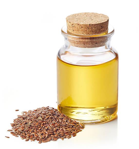 Linseed oil and linseeds Bottle of linseed oil and linseeds isolated on white background flax seed stock pictures, royalty-free photos & images