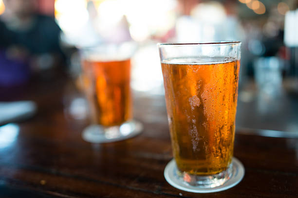 duas cervejas geladas no barra - beer bar counter bar beer glass - fotografias e filmes do acervo
