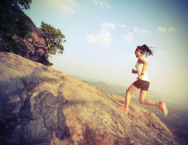 istock young asian woman runner running on mountain peak 542320924