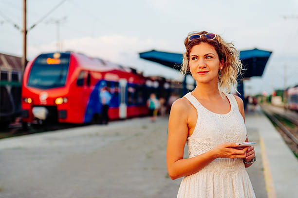 istock Beautiful woman waiting for train on railway station 542325628