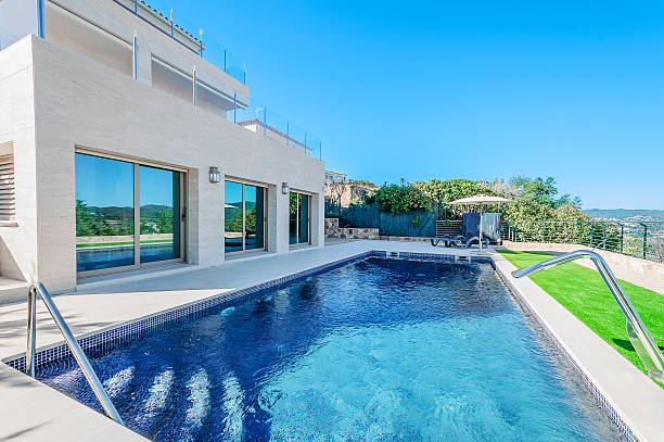 istock Luxury modern house with swimming pool with waterfall jet. House 542327722