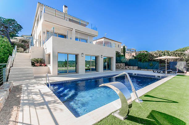 istock Luxury modern house with swimming pool with waterfall jet. House 542327754