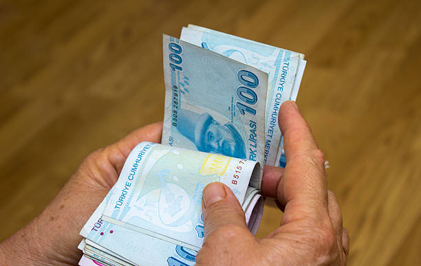Unrecognizable person counting Turkish banknotes Unrecognizable person counting Turkish banknotes. There are group of one hundred banknotes on his hands. Horizontal composiiton. Studio shot. turkish lira photos stock pictures, royalty-free photos & images