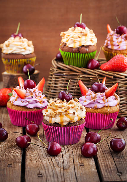 istock Delicious cupcakes decorated with caramel and fresh berries 542329784
