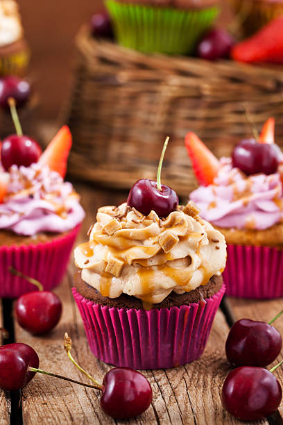 istock Delicious cupcakes decorated with caramel and fresh berries 542329880