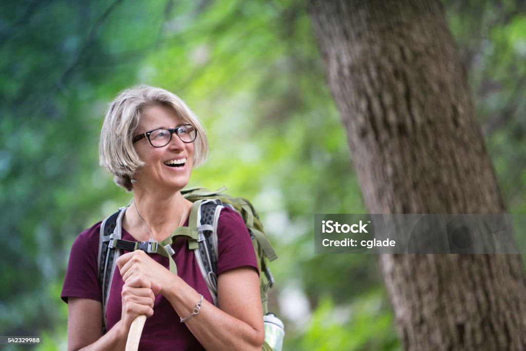 Happy Senior Woman Backpacking Enthusiastic senior woman backpacking in the forest Hiking Stock Photo