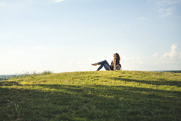 istock Woman sitting in a field on a summer day 542330690
