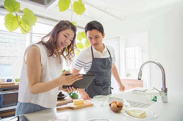 istock Young couple looking at the recipes in the digital tablet 542555606
