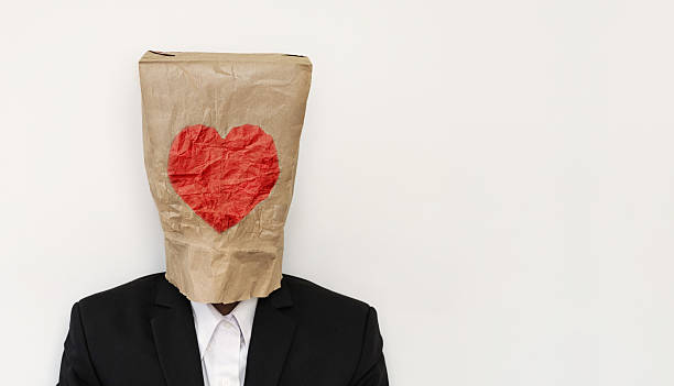 Man in suit wearing brown paper bag with heath shape a guy in suit wearing brown paper bag with heath shape anonymous businessman with paper bag on his head stock pictures, royalty-free photos & images