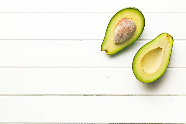 istock halved avocados on wooden background 542557008