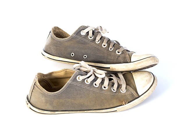 istock Used old sneakers on white background 542557018